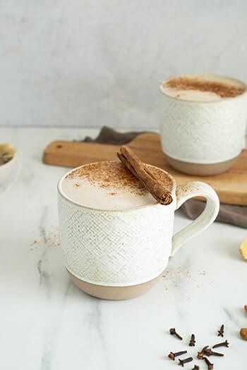 Vegan chai latte in a cup topped with cinnamon